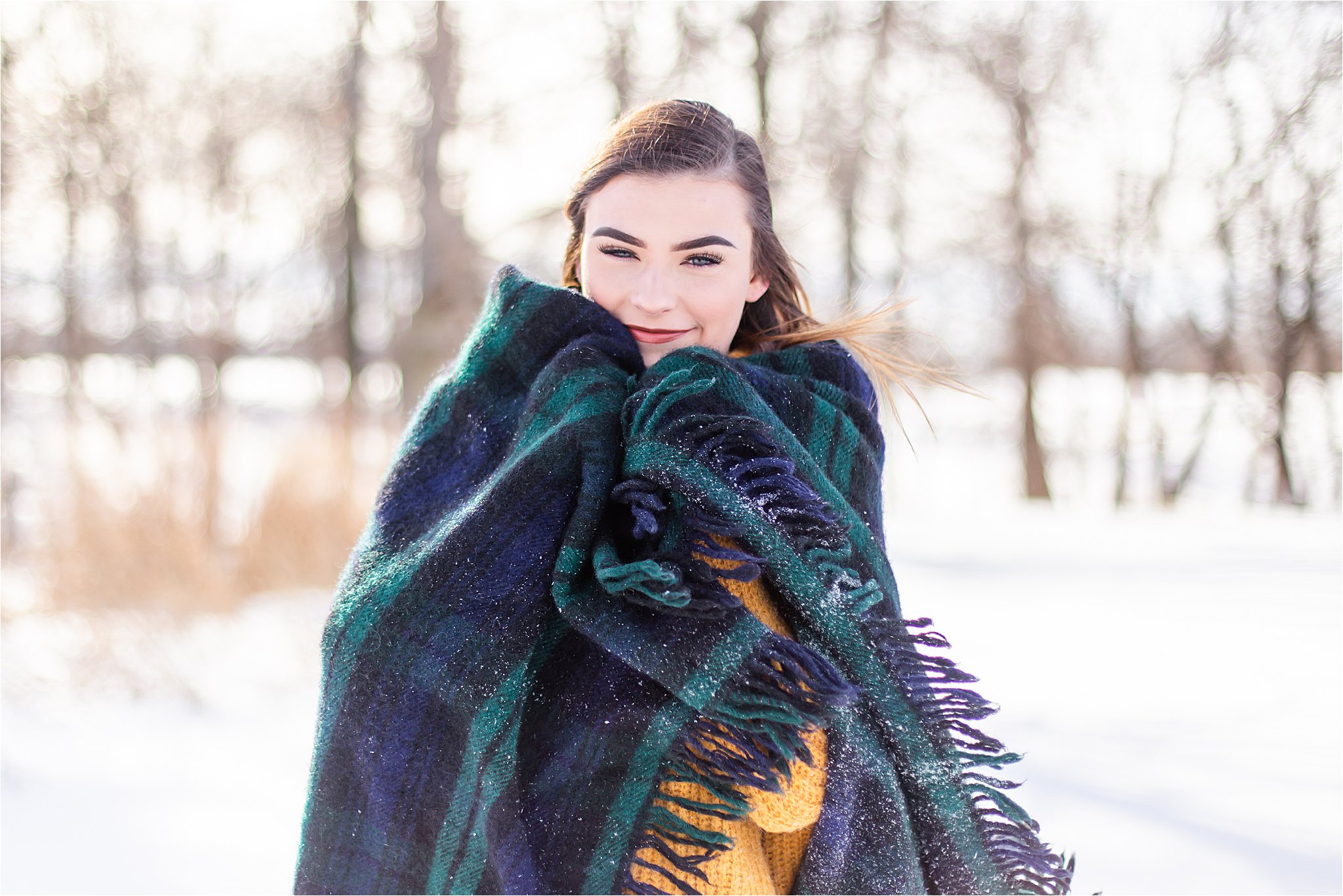Senior girl in the snow wrapped in a blanket